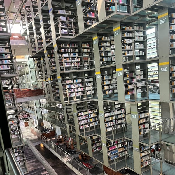 photograph of the interior of a mutli-floor library without walls so that all the shelves for all the floors are visble at once