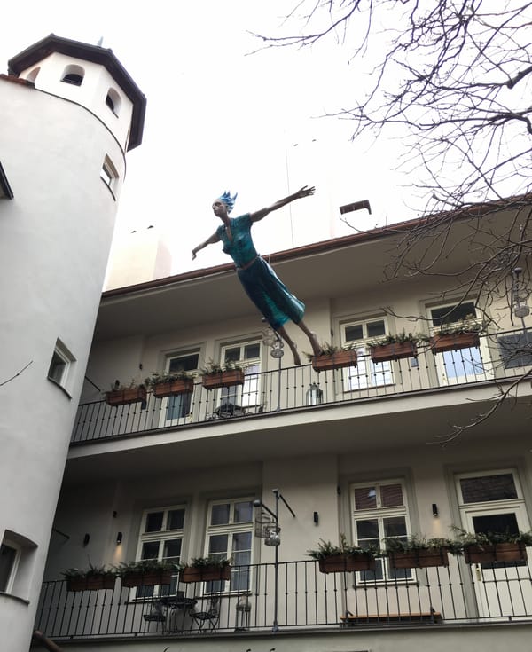 A sculpture of a woman who seems to leap from a balcony. To fly? To fall? It is unclear.